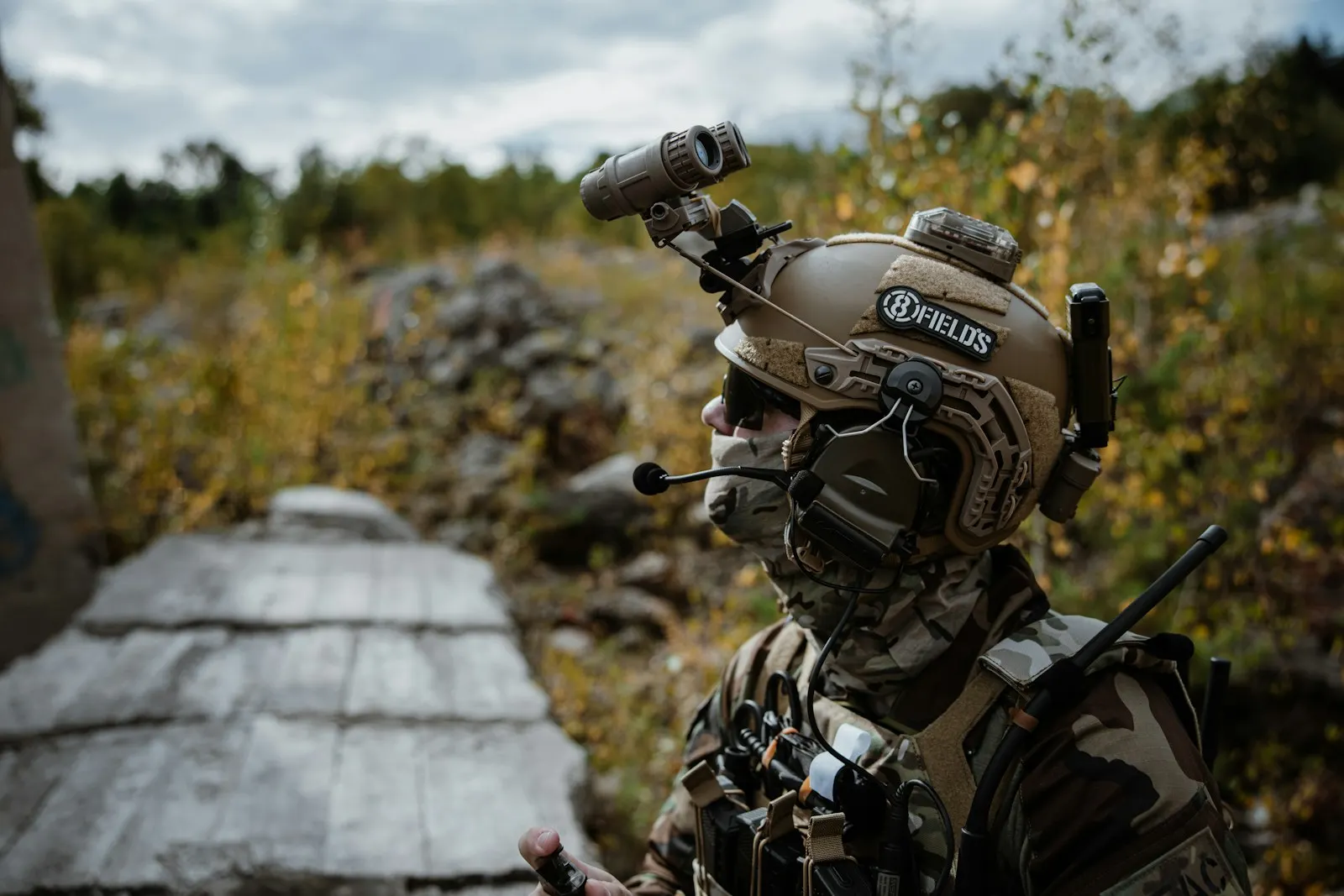 Joueur d'airsoft équipé d'un casque avec casque audio électronique et accessoires, en terrain extérieur