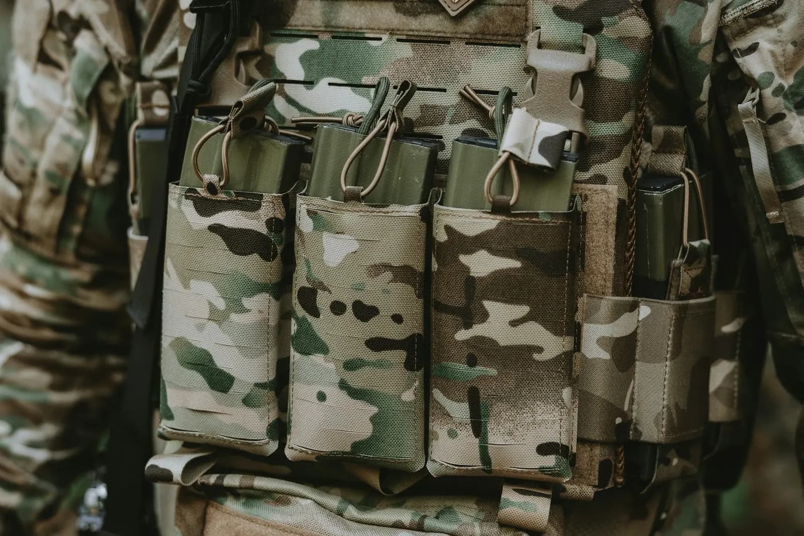 Porte-plaques camouflage multicam équipé de trois poches à chargeurs, porté par un joueur d'airsoft
